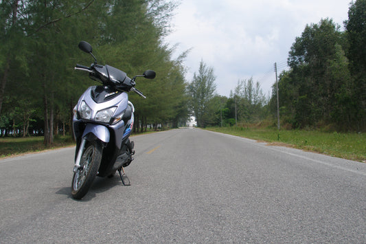 Honda Click scooter parked on a quiet road in Thailand