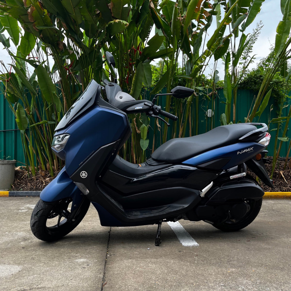 Fleet CNX blue Yamaha NMAX 155 among banana leaves
